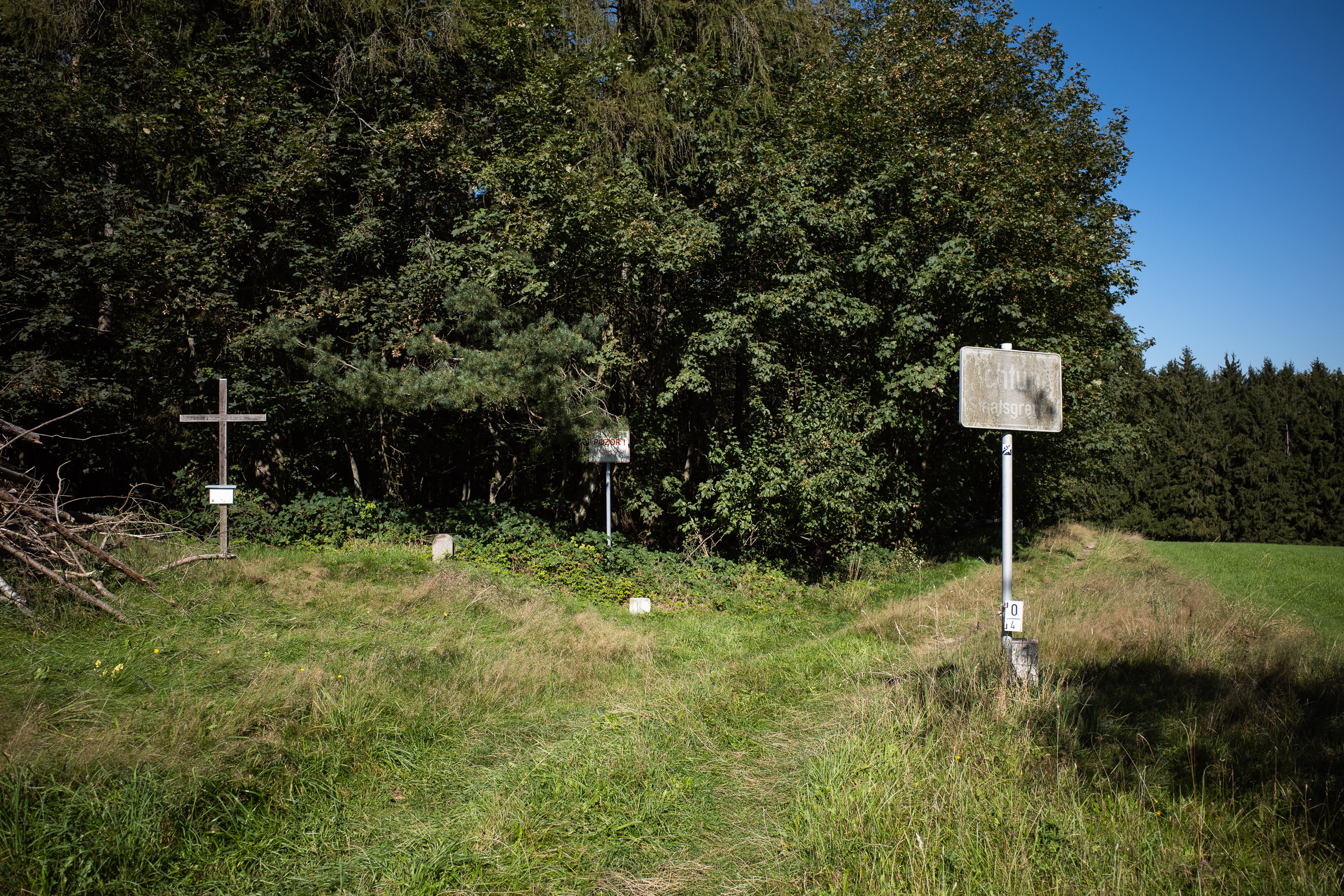 Holzkreuz, Grenzsteine und ein verblasstes Warnschild – Reste der alten Grenze